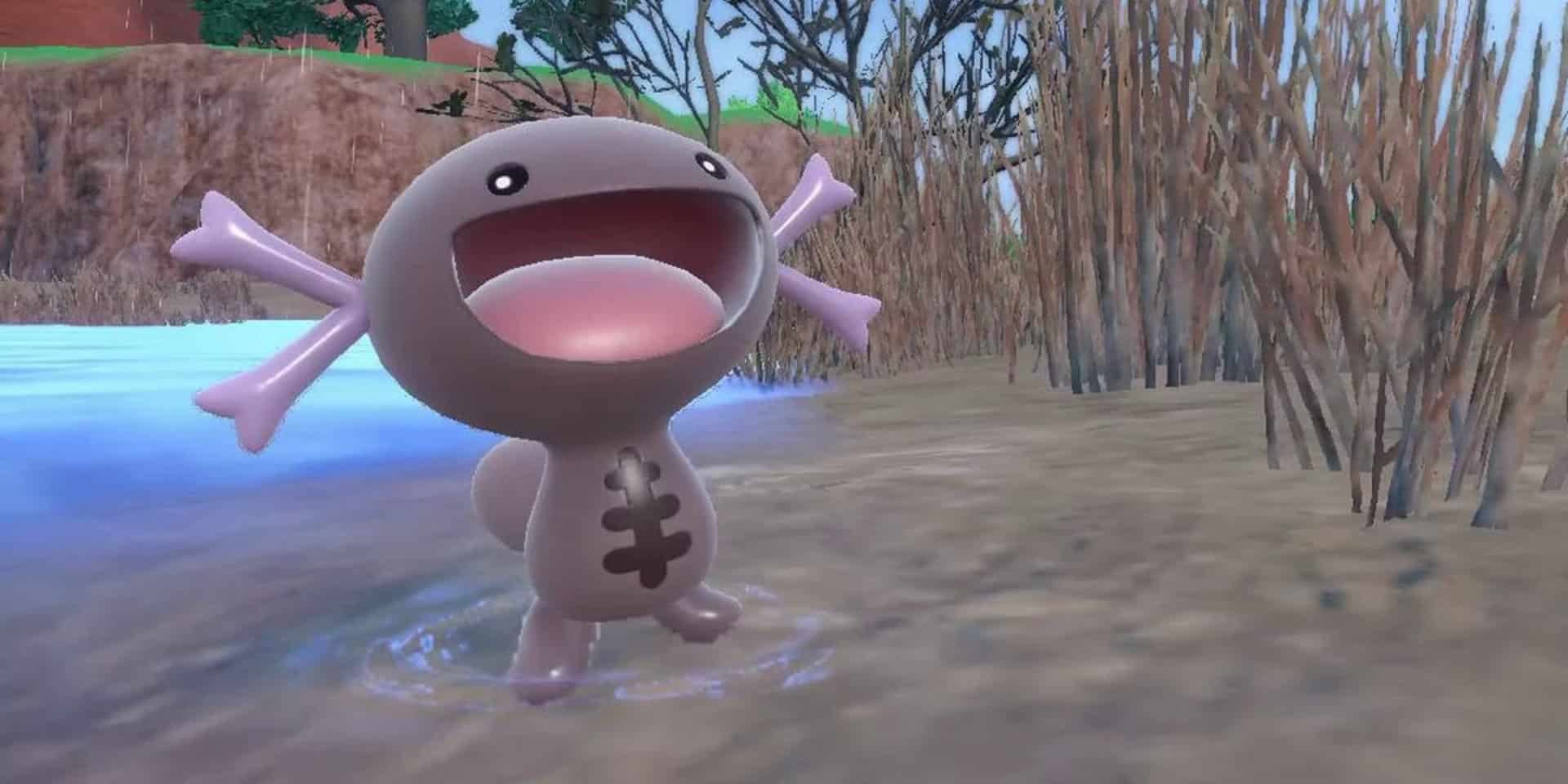 A photo from Pokémon Scarlet & Violet showing a Paldean Wooper stood on the edge of water, with reeds in the background behind it. It's mouth is open wide in joy!