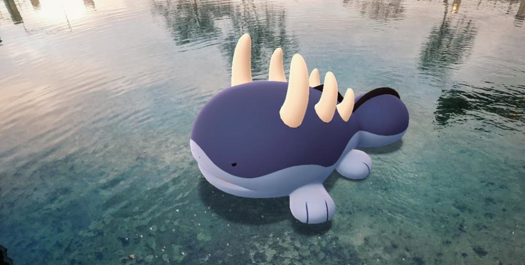 A shiny Clodsire is photographed in a shallow pool with blue water. It is shown mid attack with their spikes protruding from their back