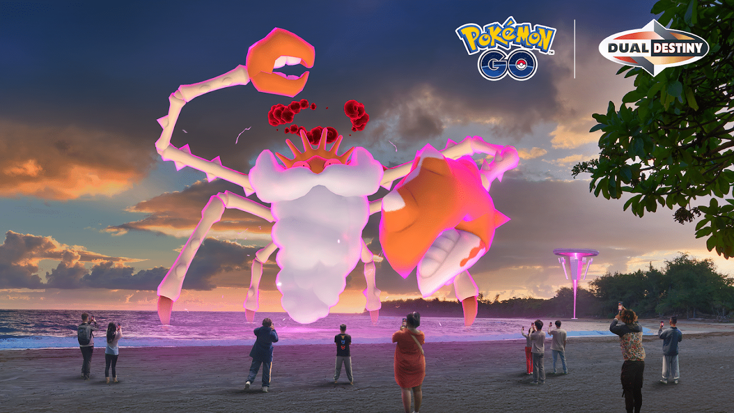 This image shows Gigantamax Kingler emerging from the ocean, next to a Power Spot, while a group of Pokémon GO Trainers stand on the beach with smartphones in hand, ready to battle it.