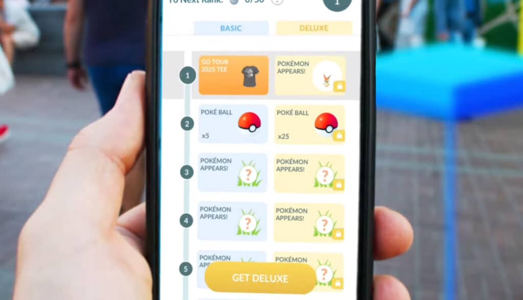 A hand holding a phone depicting the track differences between Tour Pass and Tour Pass Deluxe, which debut at Pokémon GO Tour Unova