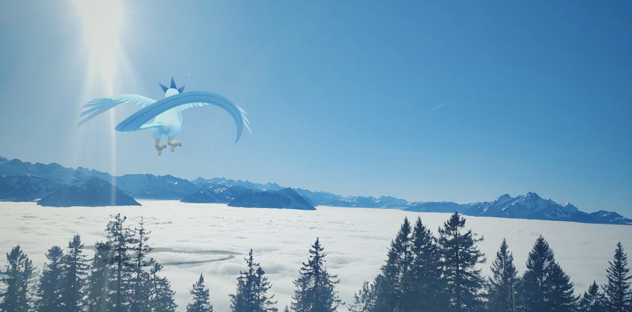 A shiny Articuno looks out across a snowy mountain range in an AR photo
