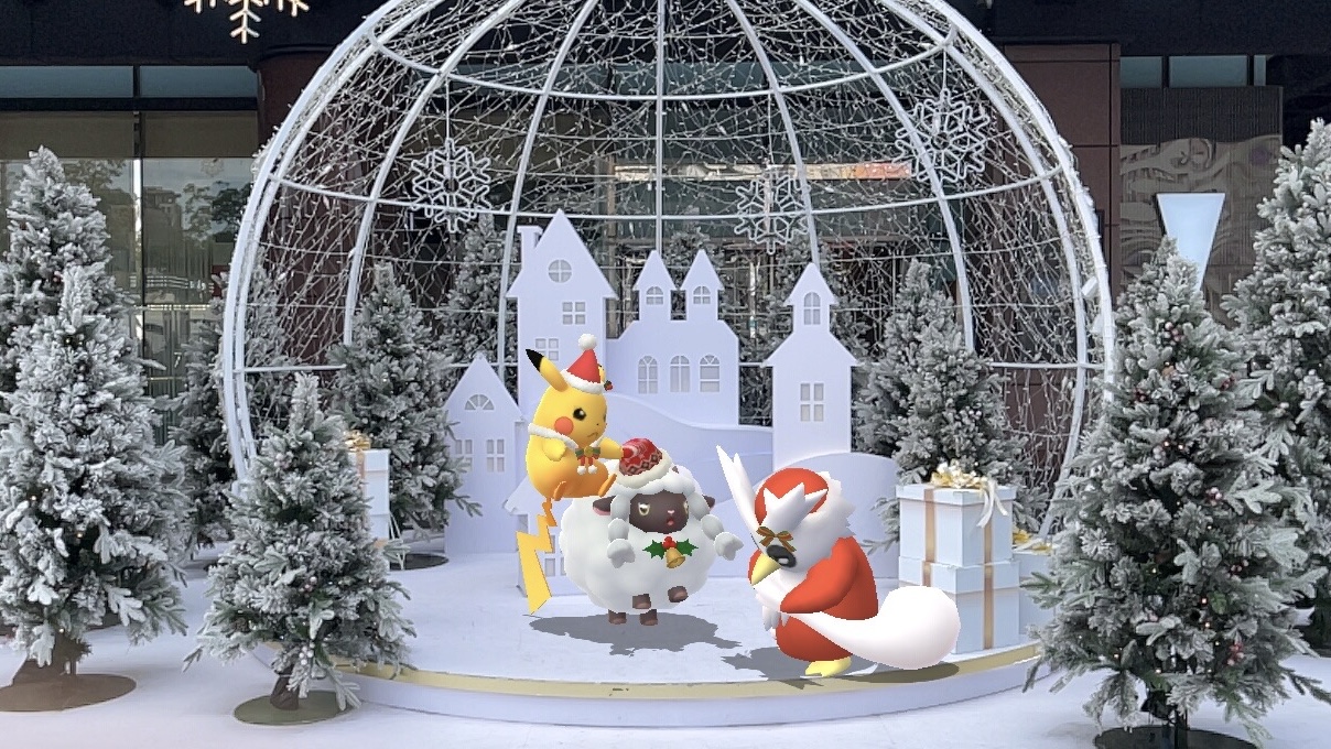 In an amazing winter wonderland setting, a costume Pikachu, costume Wooloo and costume Delibird are excited and looking at what Delibird has in their sack