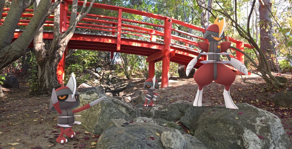 Pawniard and Bisharp stand on rocks near a red wooden bridge