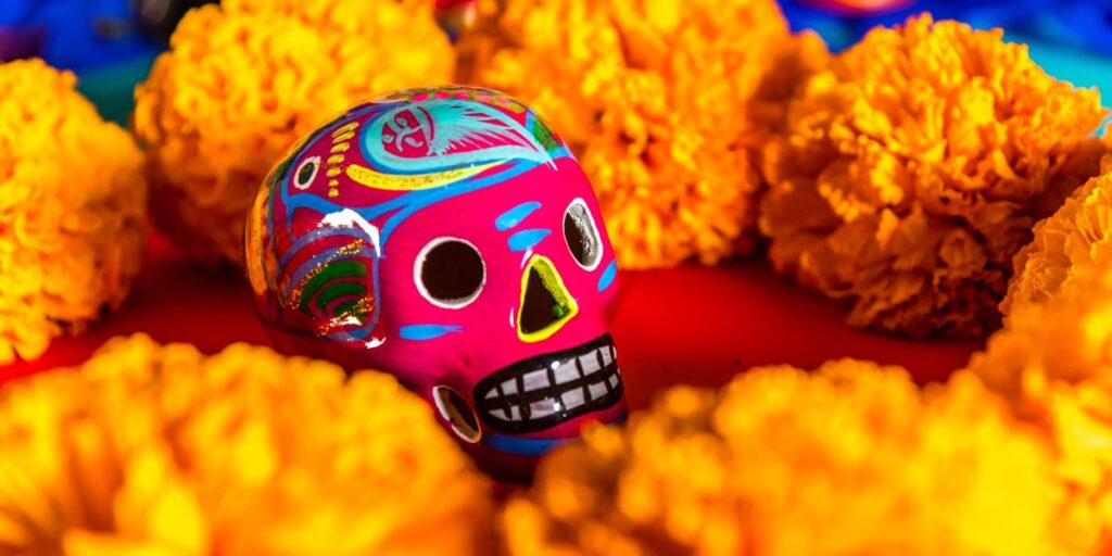 a sugar skull surrounde dby marigold flowers